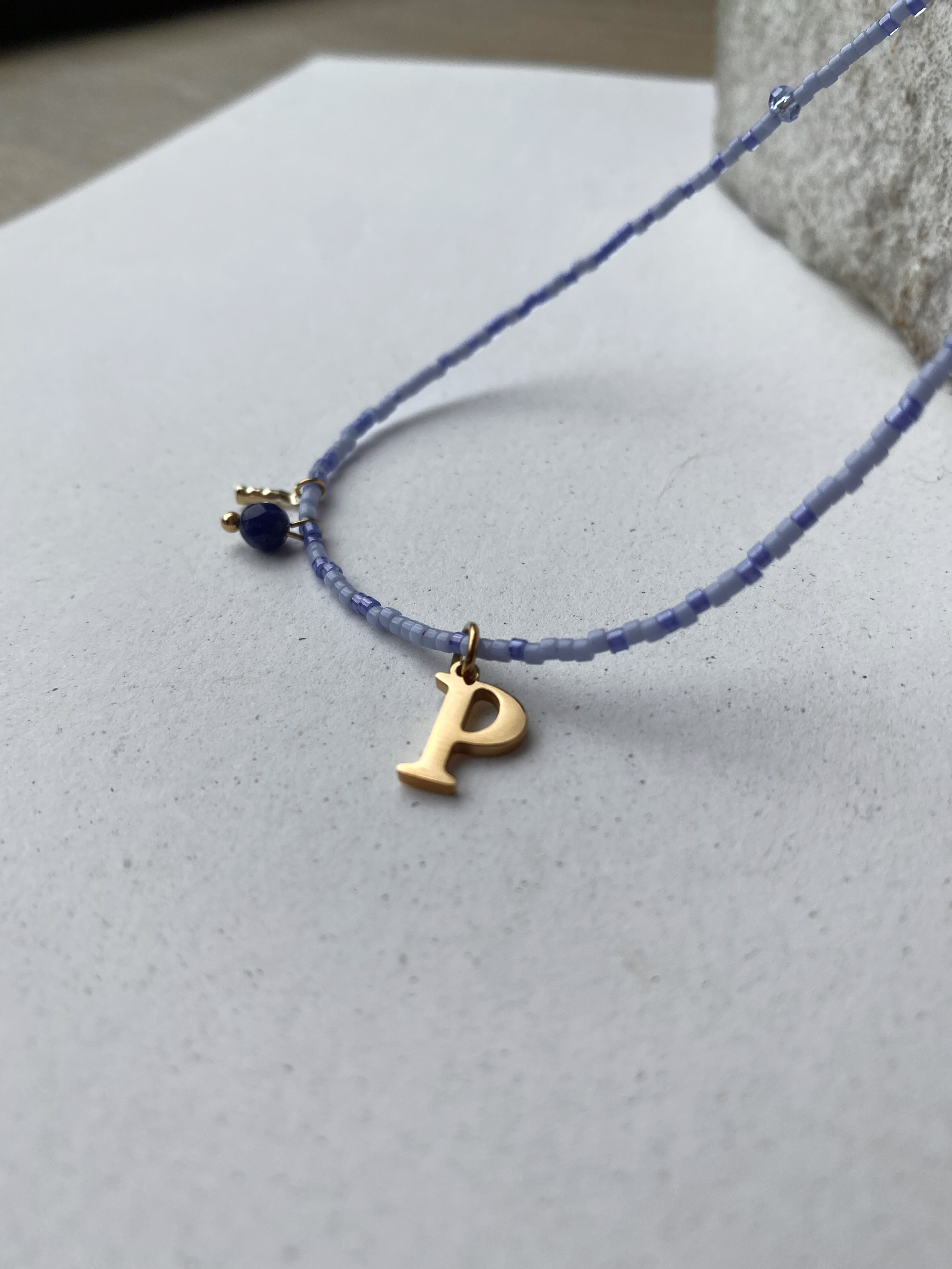 Blauwe parelketting met gouden beginletter