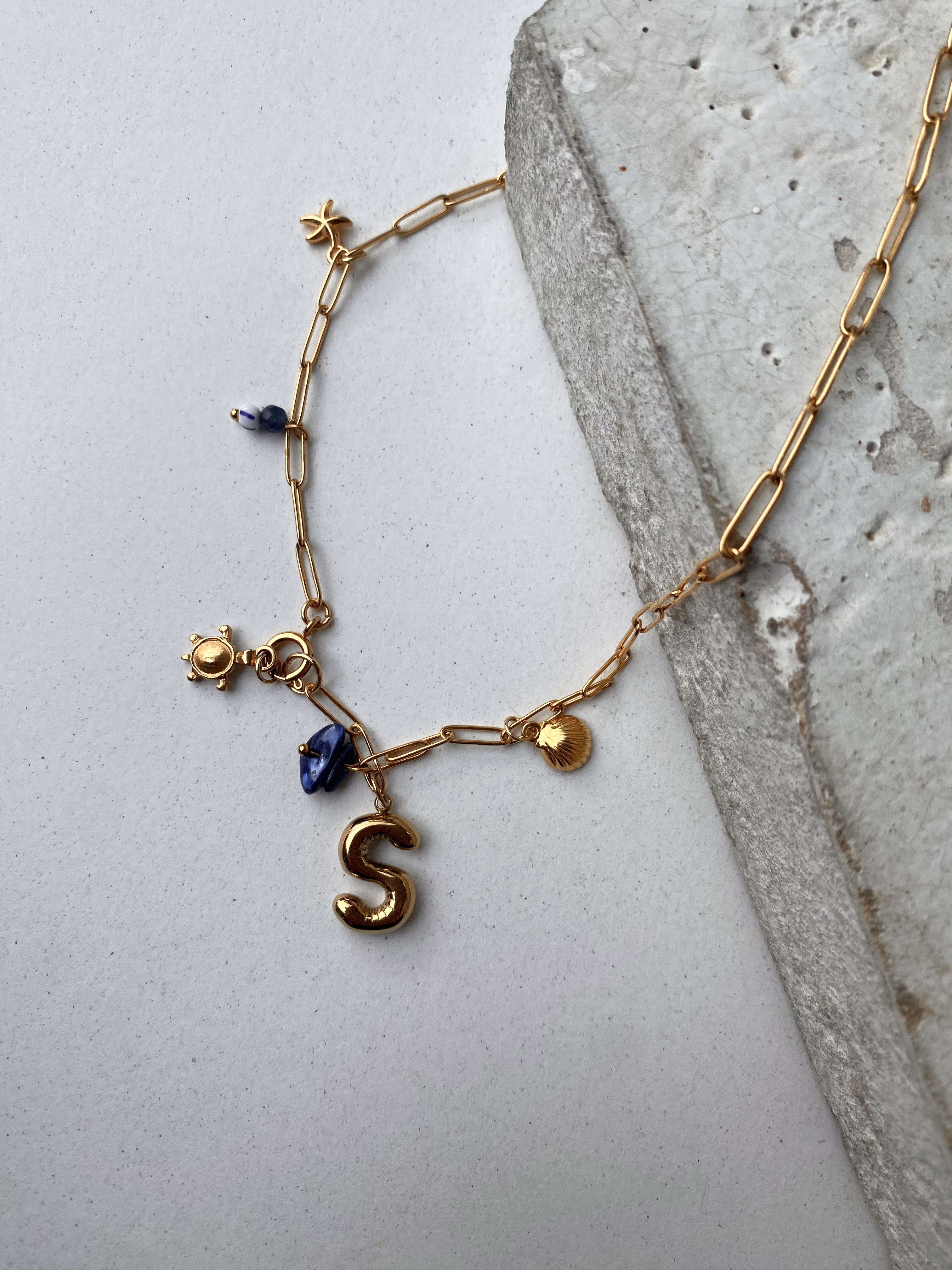 Blauwe bedelketting met gouden beginletter